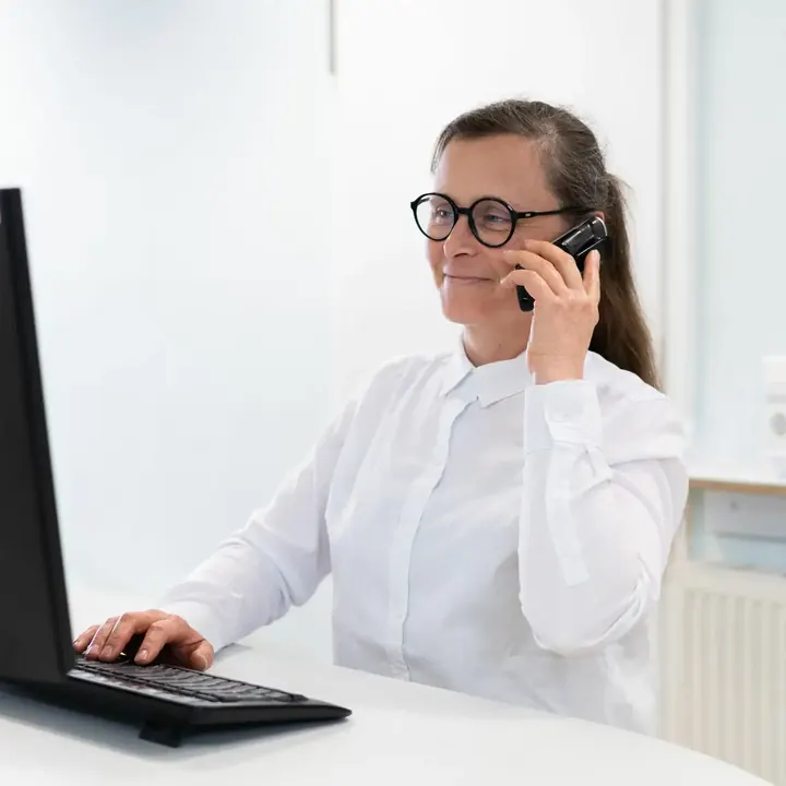 Kollegin am Telefon am Empfang
