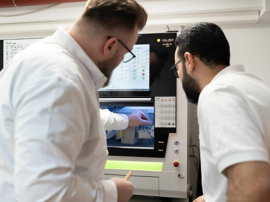 Zwei Kollegen schauen gemeinsam auf den Bildschirm einer Laborfräse