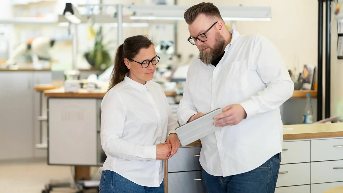 Zwei Kollegen besprechen im Labor eine Arbeit am Tablet