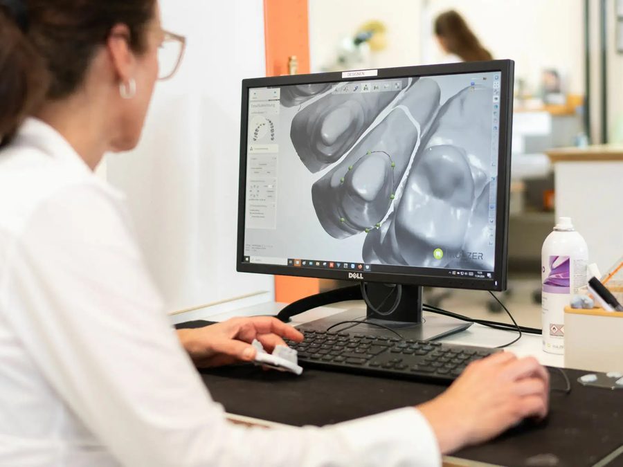 Kollegin konstruiert Zahnersatz am Bildschirm mit CAD-Software